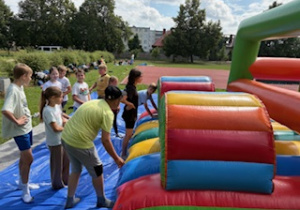 Uczestnicy półkolonii bawią się na dmuchanym torze przeszkód