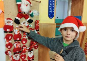 Uczeń częstuje się batonikiem z kalendarza adwentowego