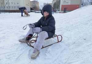 Uczeń klasy 3 B zjeżdża na sankach z górki