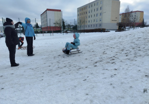 Uczennica klasy 3 B zjeżdża na sankach z górki