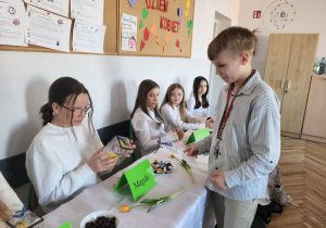 Kolega z klasy wręczający upominek koleżankom z okazji Dnia Kobiet