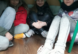 Dzieci siedzą w wybudowanym przez siebie igloo z koca