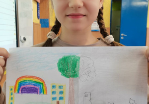 Dziewczynka prezentuje wykonany przez siebie plakat.