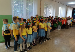Uczniowie w swoich bajkowych strojach stoją na holu szkoły.