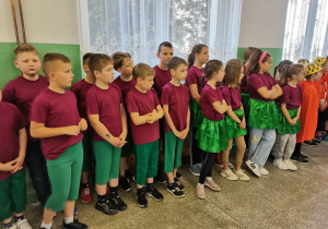 Uczniowie w swoich bajkowych strojach stoją na holu szkoły.
