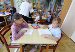 Dzieci uzupełniają jedną z kart pracy.