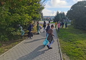 Dzieci sprzątają teren wokół szkoły.