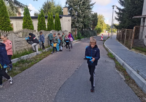 Dzieci sprzątają teren wokół szkoły.
