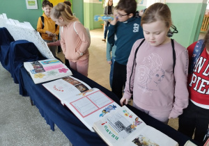 Dzieci oglądają kroniki szkoły.