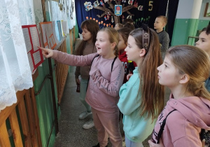 Dzieci odczytują wyeksponowane prace.