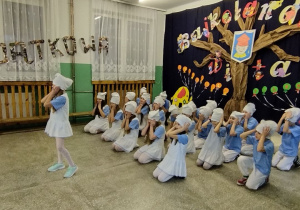 Uczestnicy Dnia Otwartego siedzą w holu szkoły.