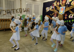 Uczestnicy Dnia Otwartego siedzą w holu szkoły.