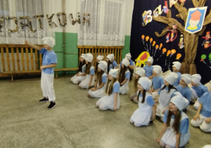 Uczestnicy Dnia Otwartego siedzą w holu szkoły.
