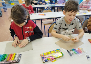 Uczniowie lepią "pizzę" z plasteliny.