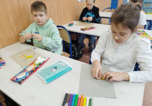 Uczniowie lepią "pizzę" z plasteliny.