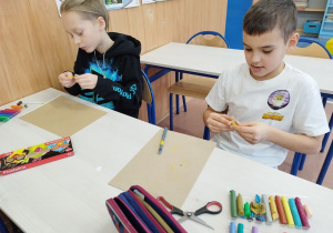 Uczniowie lepią "pizzę" z plasteliny.