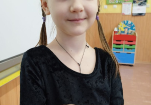 Uczennica pokazuje swoją plastelinową pizzę.