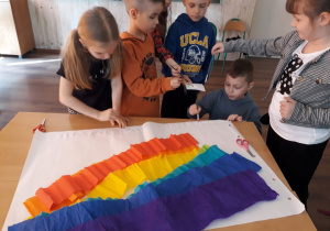 Dzieci przygotowują plakat tęczy.
