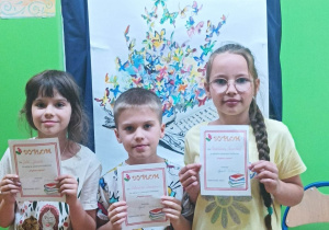 Uczniowie z klasy IIC trzymają dyplomy za udział w szkolnym konkursie "Pięknie czytam"