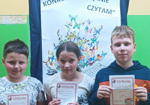 Uczniowie z klasy IIIA trzymają dyplomy za udział w szkolnym konkursie "Pięknie czytam"