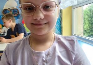Dziewczynka prezentuje znaczek "Mała książka Wielki człowiek"
