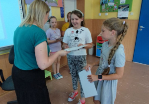 Pani bibliotekarka wręcza dyplomy i nagrody książkowe