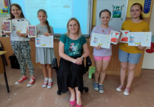 Dziewczynki pozują do zdjęcia z panią bibliotekarką