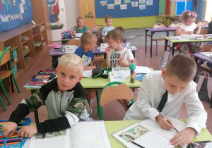 Uczniowie klasy I A pracują w ławkach.