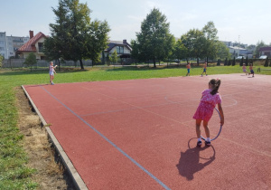 Dziewczynki toczą do siebie koła.