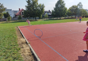 Dziewczynki toczą do siebie koła.