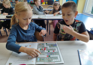 Uczniowie klasy I B grają w matematyczną grę planszową .