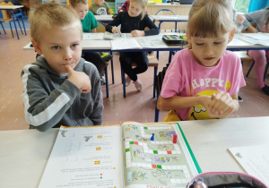 Uczniowie klasy I B grają w matematyczną grę planszową .