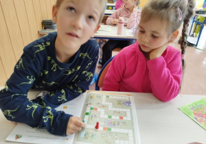 Uczniowie klasy I B grają w matematyczną grę planszową .