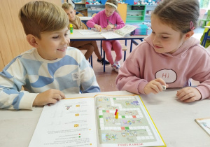 Uczniowie klasy I B grają w matematyczną grę planszową .
