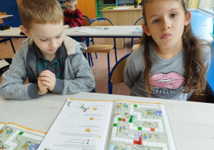 Uczniowie klasy I B grają w matematyczną grę planszową .