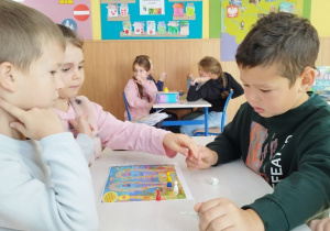 Uczniowie grają w grupach.