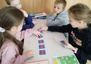 Uczniowie grają w grupach.