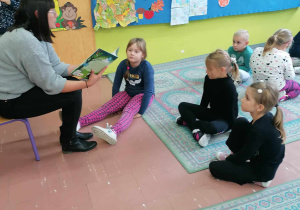Uczniowie z klasy I A słuchają czytanej książki.