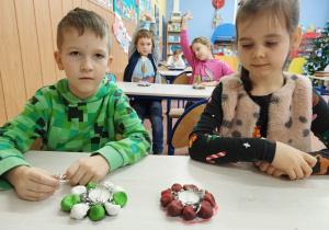 Dzieci prezentują świeczniki z kasztanów.