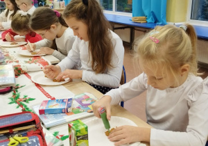 Dzieci ozdabiają pierniczki kolorowym lukrem