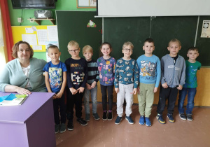 Uczniowie i pracownica Bajkolandii w niebieskich strojach