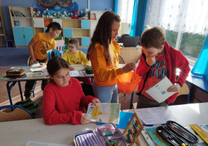 Dziewczynka częstuje kolegów słodyczami z okazji Dnia Dyni