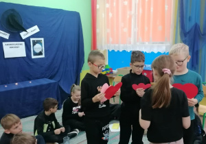 Uczniowie przebijają serca z imionami.
