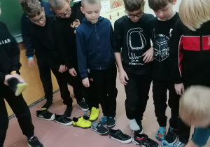 Dzieci układają buty.
