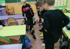 Dzieci układają buty.