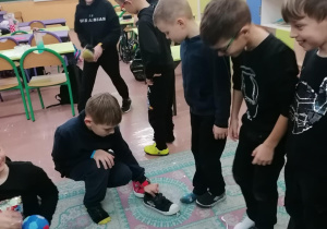 Dzieci układają buty.