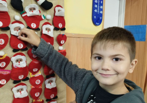 Dziecko wyjmuje upominek z klasowego kalendarza adwentowego