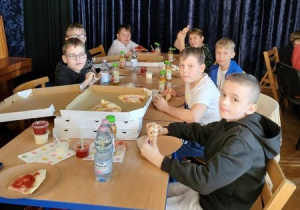 dzieci jedzą pizzę po treningu