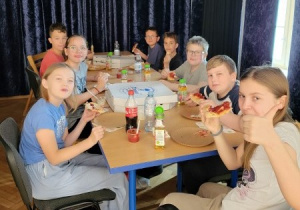 dzieci jedzą pizzę po treningu