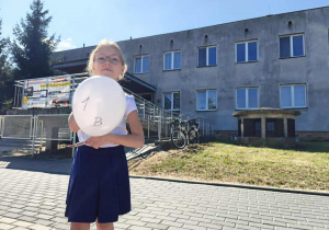 Uczennica klasy 1 b stoi przed Bajkolandią